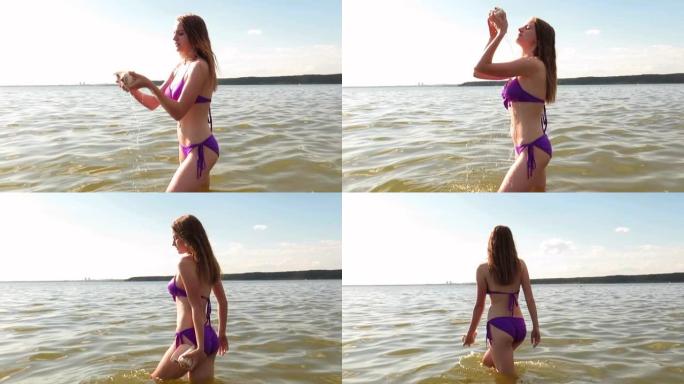 一个穿着比基尼的苗条身材的年轻女子从贝壳上倒水