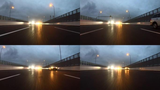 黄昏下雨天在高速公路上行驶。向后看
