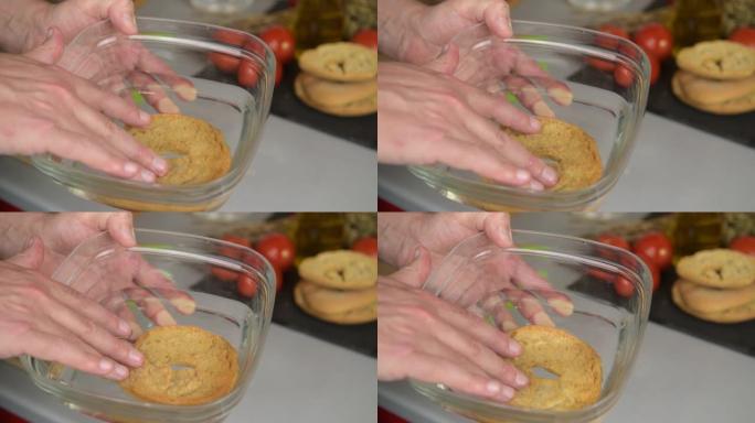 在食用前，用手将一个frisa tipical apulian盘放入水中弄湿