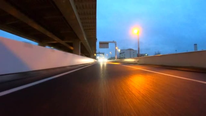 黄昏下雨天在高速公路上行驶。向后看