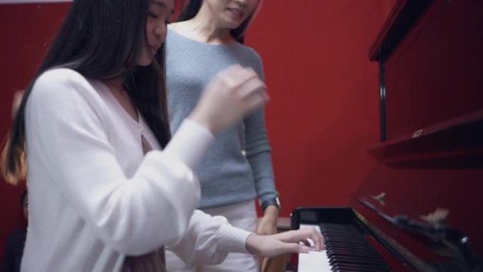 亚洲女音乐导师，与她的学龄前女学生一起工作。