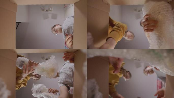 三个孩子把东西打包到纸板箱里