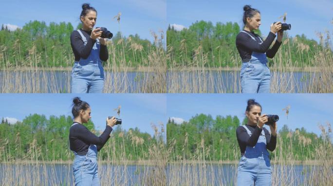 湖岸的女人手里拿着相机拍照