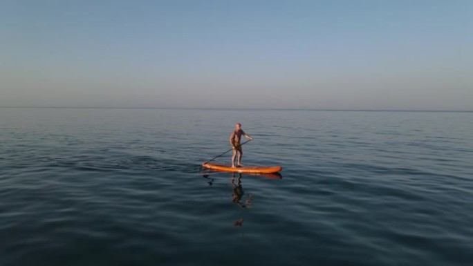 夏天，男人在海边站起来划板