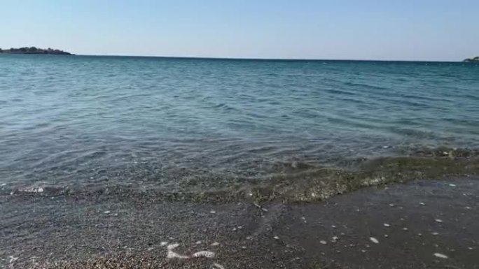 在旅游爱琴海小镇 “Sigacik” 的 “Akarca” 海滩上的爱琴海小浪的镜头。这是土耳其伊兹