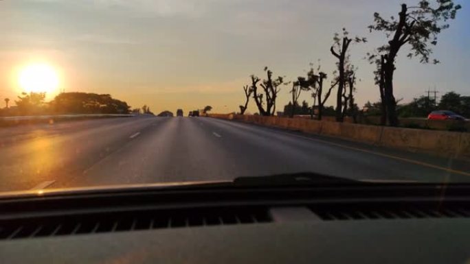 在道路上行驶，在智能手机慢动作的正面拍摄日落