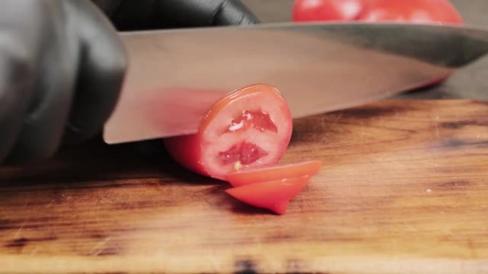 人用菜刀将新鲜的红番茄切成木砧板。健康饮食。想法烹饪沙拉或蔬菜的不同菜肴