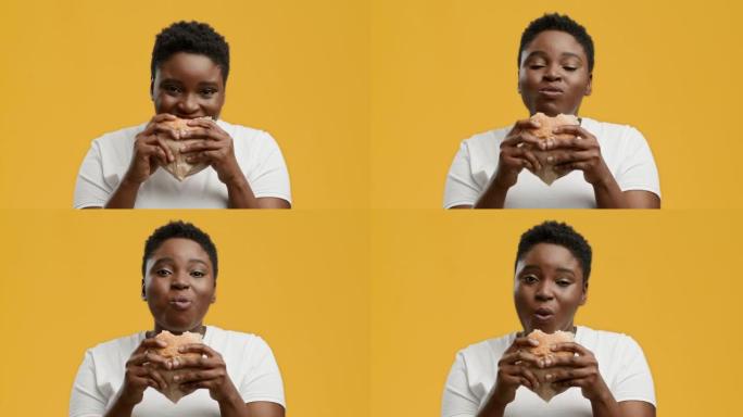 快乐肥胖的非洲裔美国妇女在黄色背景上吃汉堡