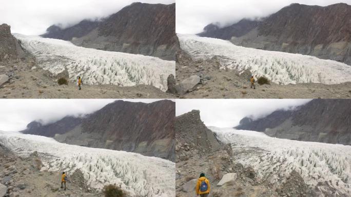 穿着黄色夹克看着巴基斯坦冰川的女人的风景鸟瞰图