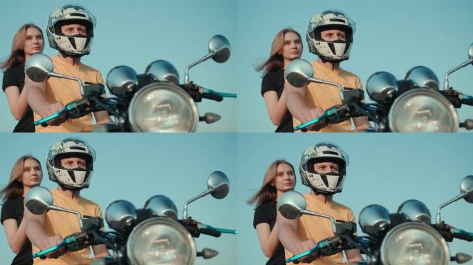 一个男孩和一个女孩坐在摩托车上，望着远处