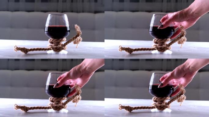 将酒倒入玻璃杯中并用绳子绑住。酒精依赖的概念