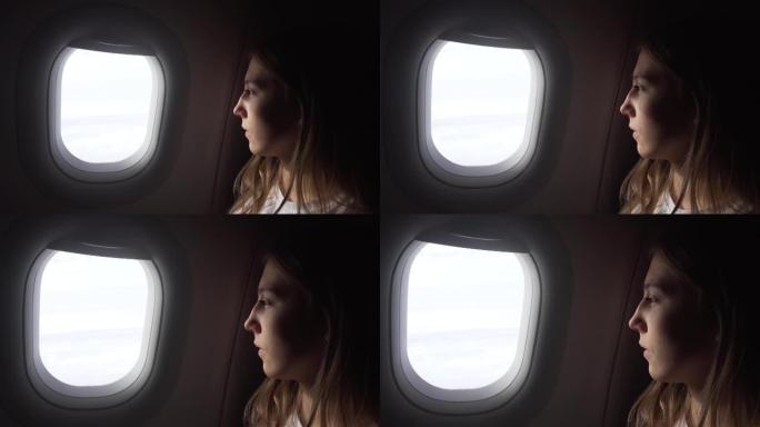 坐在飞机窗户边向外看的女孩