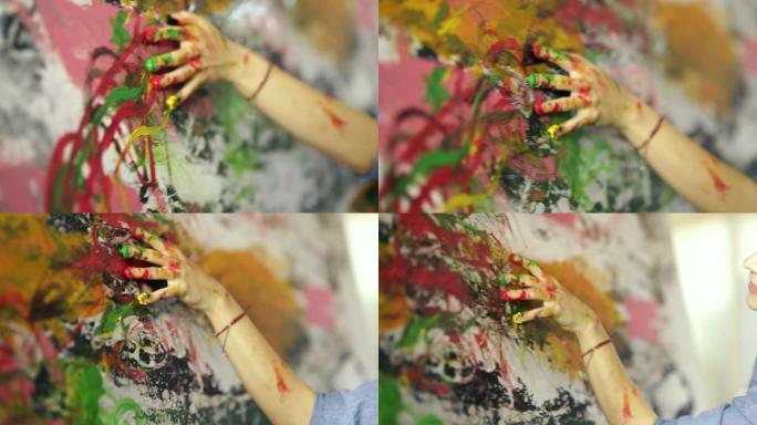 释放你的创造力。年轻女子用手指在画布上涂漆的手的特写，在家庭工作室创作一幅画