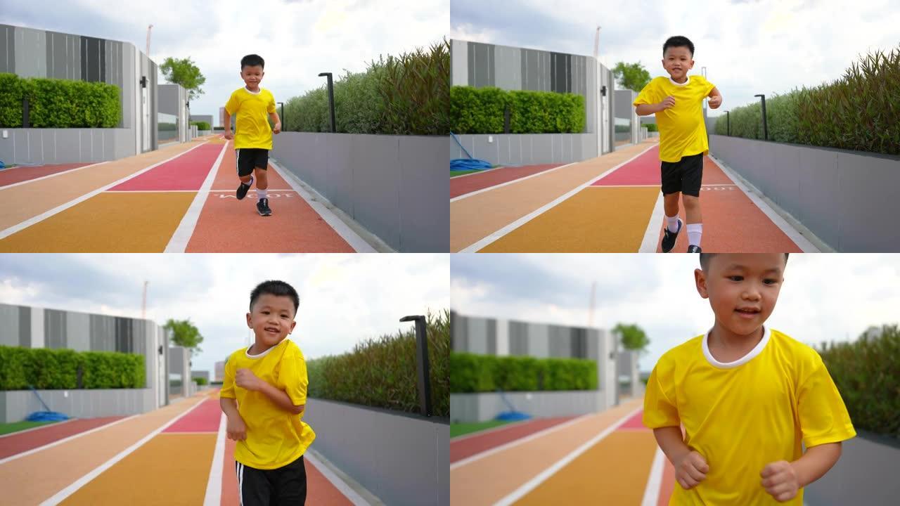 亚洲男孩在赛道上练习跑步
