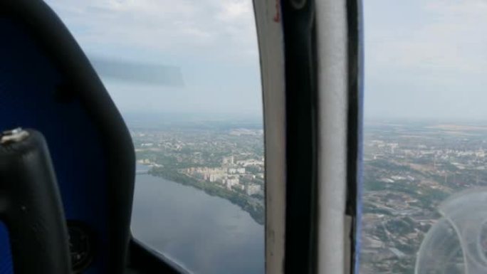 一架小型客机舷窗的视野。大都市的俯视图是第聂伯河沿岸的一条大绿色河流，其中建造了房屋和桥梁