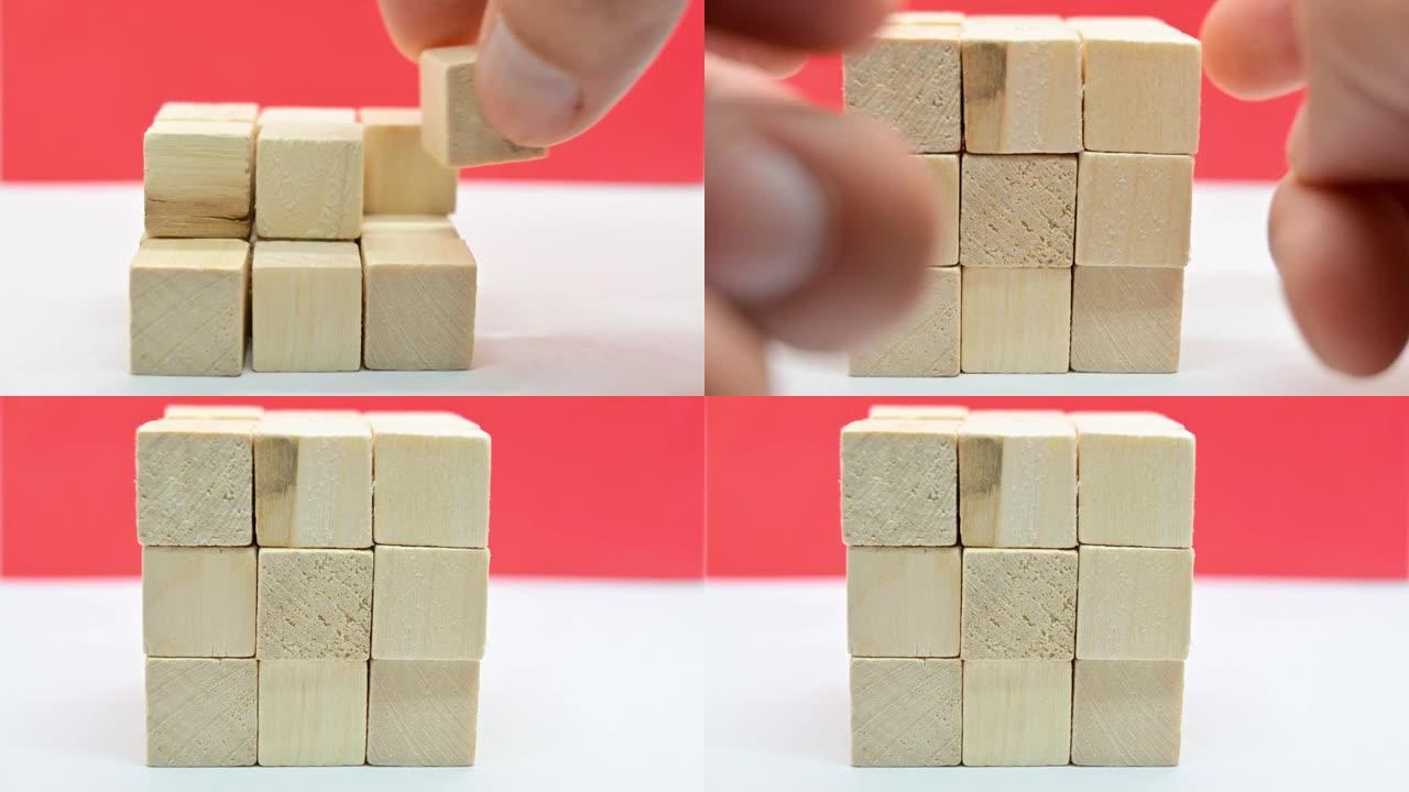 人的手制作一个小方块的木制立方体的近距离延时视频。
