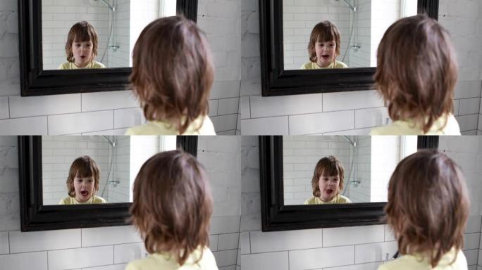 滑稽的长发学龄前儿童把脸拉进镜子里
