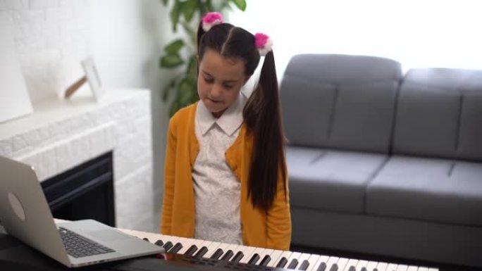 弹琴的小女孩。笔记本电脑与老师在线音乐课