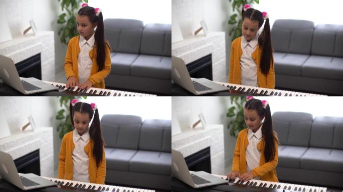 弹琴的小女孩。笔记本电脑与老师在线音乐课