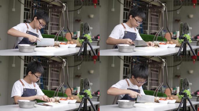 亚洲华裔少年男孩在后院厨房教授烹饪广播。