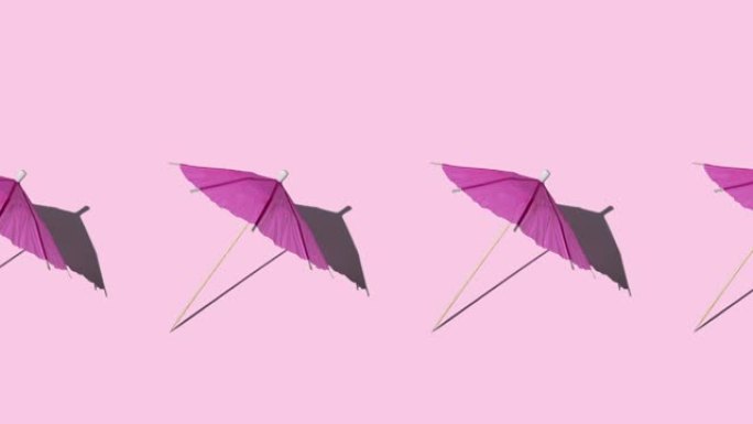 夏季模型的无缝循环动画，在正午的阳光下有许多粉红色的海滩或鸡尾酒伞，阴影坚硬。带复制空间的最小旅行概