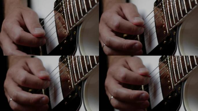 吉他手用红色拨片在白色电吉他上演奏旋律