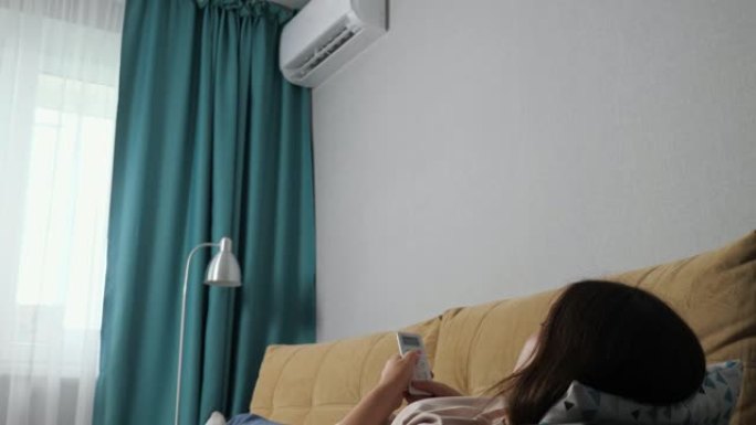 面目全非的女人用遥控器打开空调，躺在沙发上