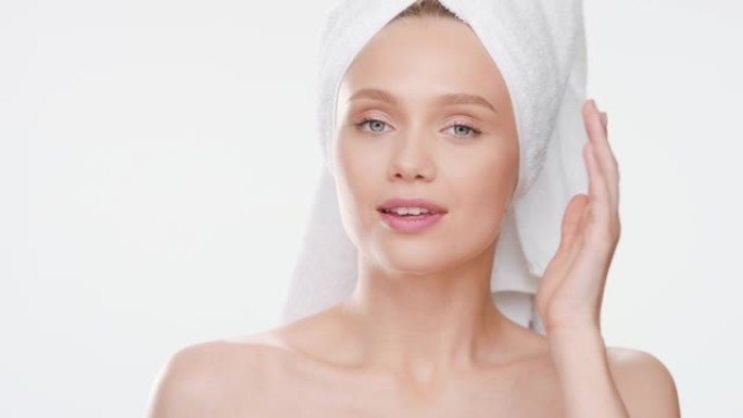 女孩触摸脸颊转向相机，并为此微笑