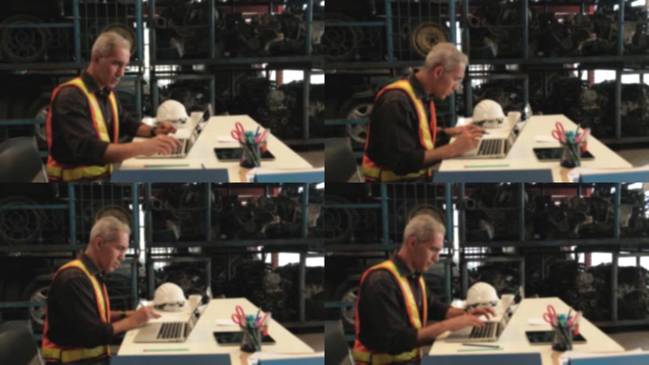 模糊焦点VDO: 高加索男性工程师专注于办公桌工作。在备件仓库中使用笔记本电脑检查汽车发动机和汽车行