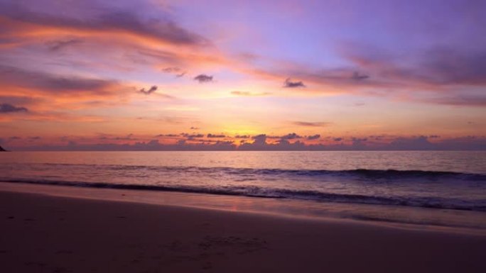 戏剧性的海上日落或日出燃烧的紫色天空和闪亮的白浪撞击在沙滩上美丽的光线反射在海面上惊人的风景或海景背