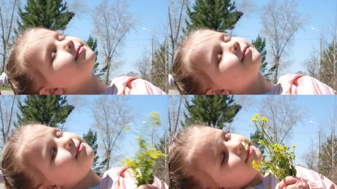 快乐的孩子在户外享受大自然。春天。肖像一个闭着眼睛的微笑女孩。美丽的白日梦小女孩拿着花束春天的黄色花