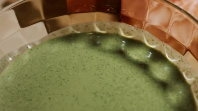 在玻璃碗中混合煎饼面糊和新鲜的菠菜叶。准备彩色煎饼的过程。4k视频