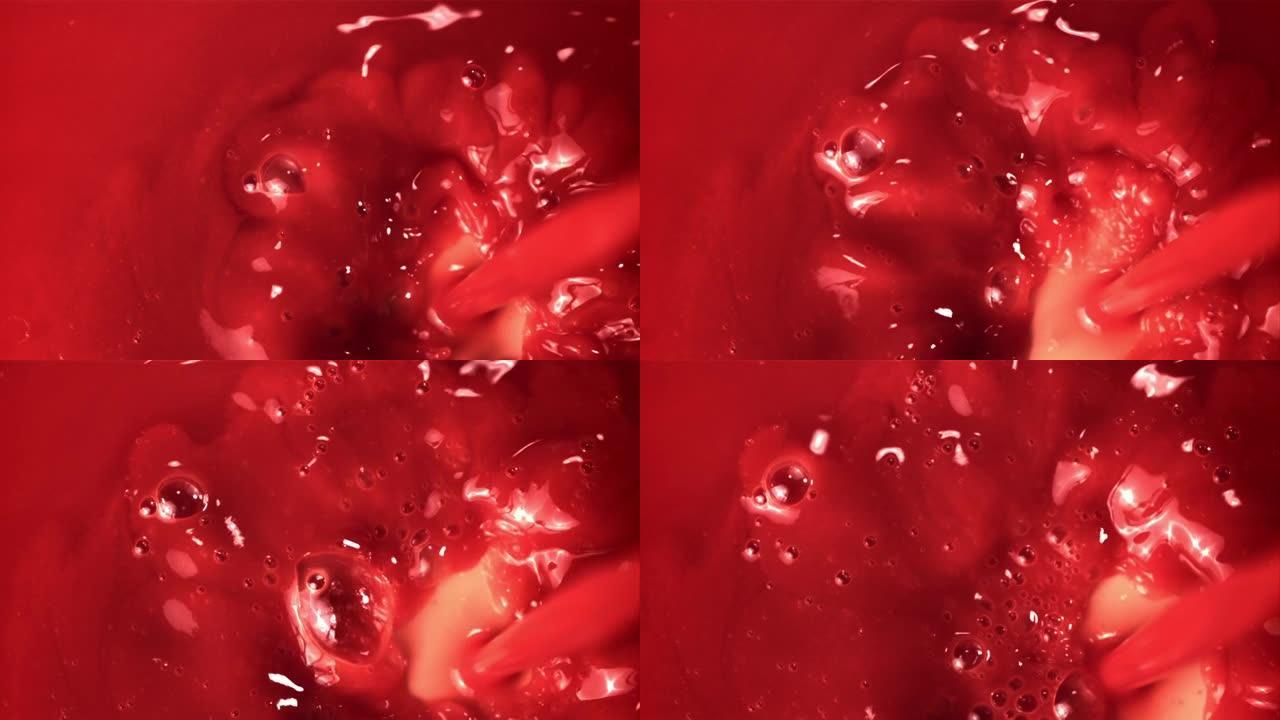 超级慢动作番茄汁倒入气泡。以1000 fps的高速相机拍摄。