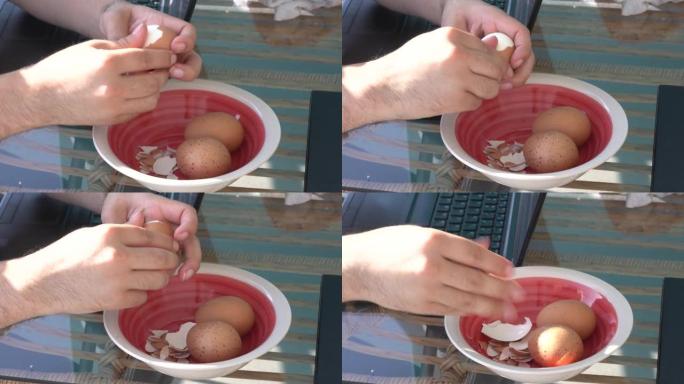 特写手取下煮鸡蛋的外壳，在4k的早晨作为早餐吃
