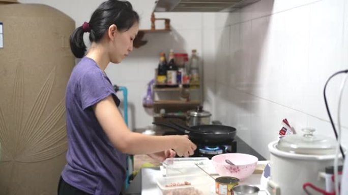 亚洲女性在家厨房做饭。