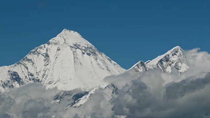 时光倒流的云在山谷中盘旋，远处是雪峰。野马、尼泊尔、安纳普尔纳