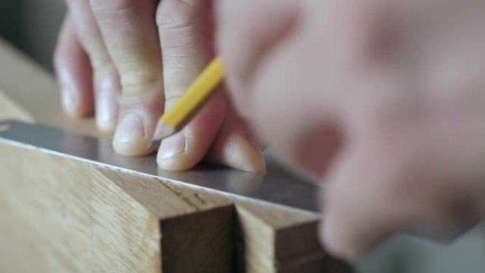 木匠用尺子和铅笔在木板上做标记。木工艺术。手工木工工具的声音
