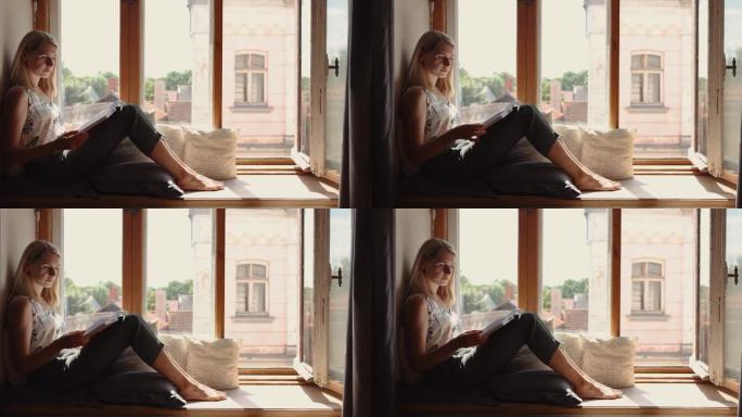 年轻女子坐在舒适的阳光明媚的窗台上看书