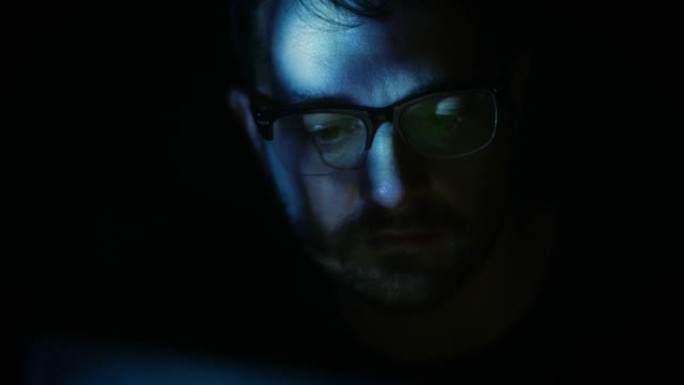 男人通过蓝色数字光使用平板电脑