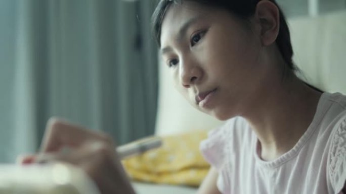亚洲女孩坐在地板上，在家用数字笔和平板电脑画画，生活方式概念。