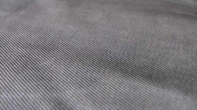 吉恩灰色牛仔布的宏观照片。现代服装纺织品，详细的时尚材料。