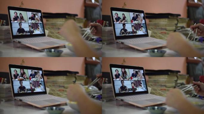 亚洲华裔年轻女子在家吃饭时与家人朋友一起在笔记本电脑前视频通话