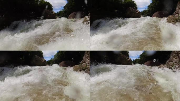 靠近水上慢动作瀑布摄像机向上游移动，飞溅向摄像机