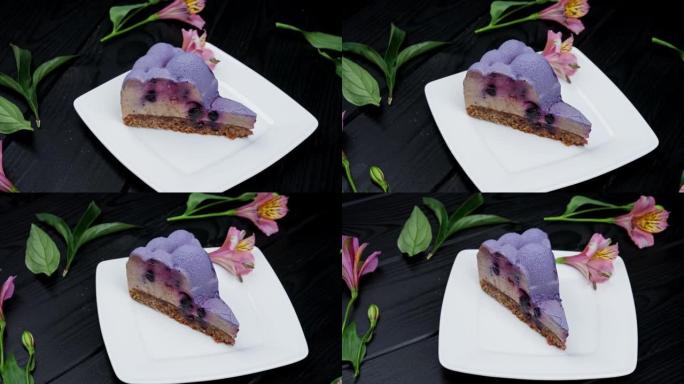 在木制背景上的白色盘子上放蓝莓和黑醋栗的芝士蛋糕切片