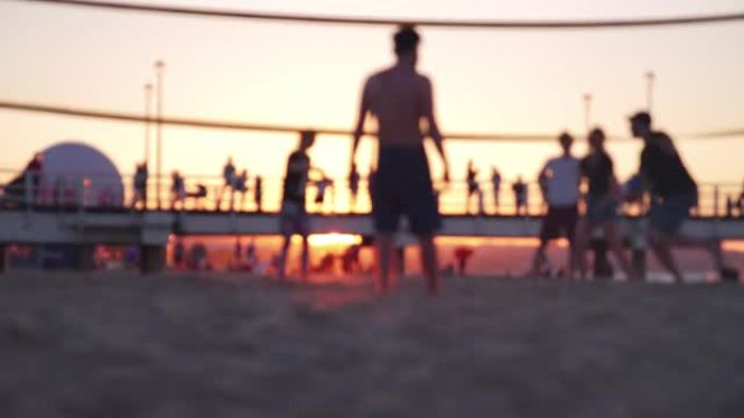 年轻的匿名人士在日落黄金时段在沙滩上打排球