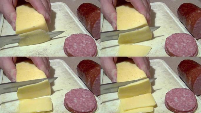 一名男子用一把锋利的大刀将坚硬的奶酪在砧板上切成碎片，旁边是切成薄片的香肠。特写