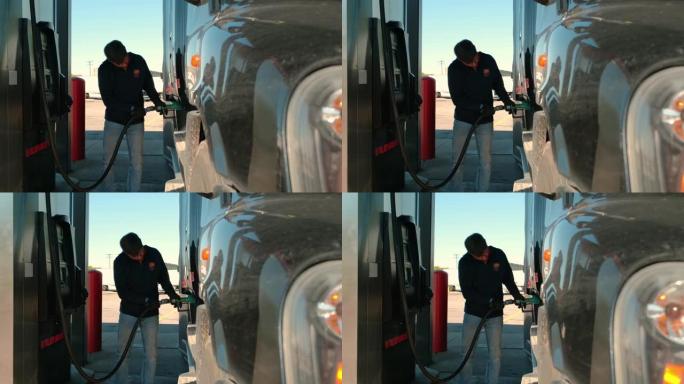 男子在卡车加油站给卡车加油，