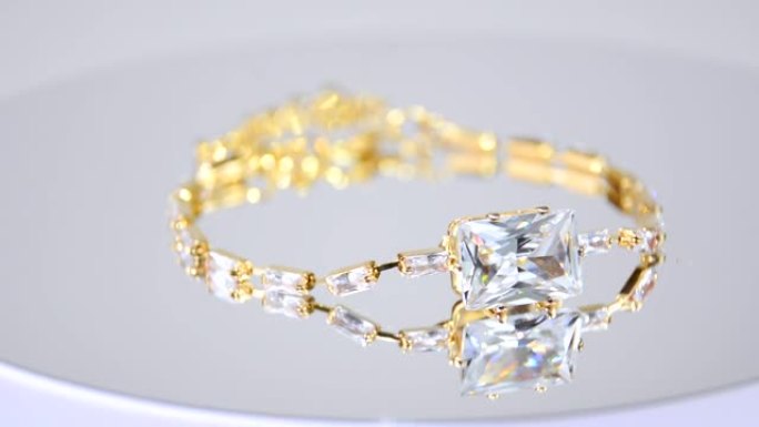 奢华昂贵的金色手镯。白色反光孤立背景的奢华珠宝，带有复制空间。