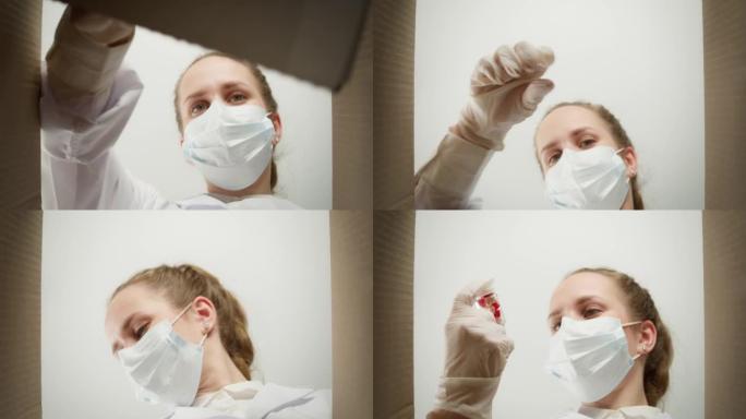 戴着医用口罩和手套的年轻女医生从盒子里吃药。女护士打开药物递送包装，打开包裹，服用片剂和药丸。药房运