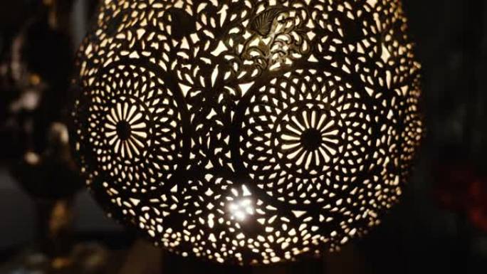 点燃的摩洛哥阿拉伯黄铜灯，带有复杂的花卉图案。